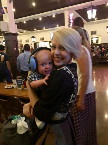 a girl in a dirndl holding a baby at an oktoberfest celebration