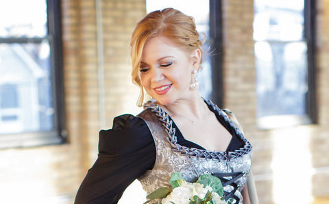 woman wearing a grey and black bridesmaid dirndl at a German themed wedding