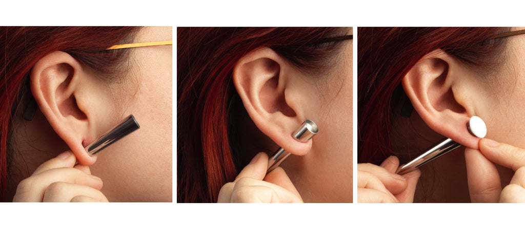 A women showing how to slowly and safely stretch ears using surgical steel tapers.