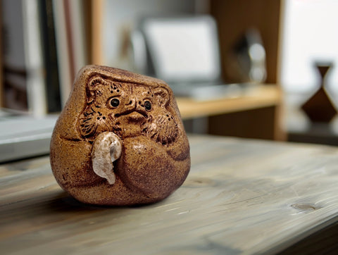 tanuki Daruma statue on desk