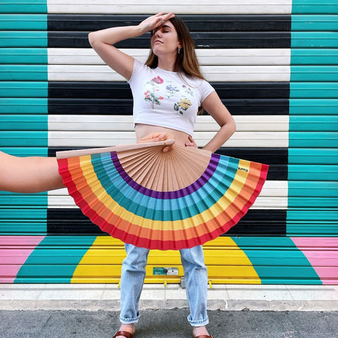 Chica en Gnomo con un abanico de arcoiris como falda