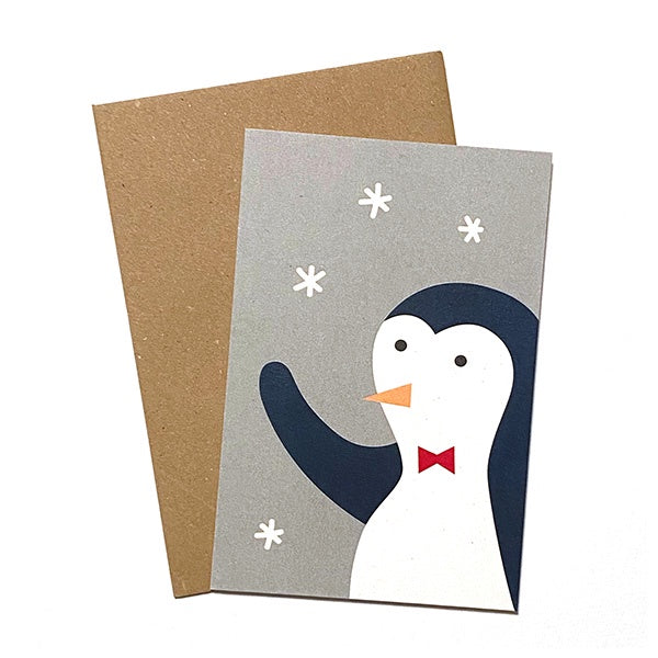 Tarjeta de navidad con un pingüino saludando y sobre de papel craft ilustrada por Elisa Talens