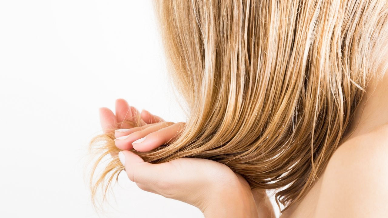 Mulher aplicando óleo de amêndoas no cabelo