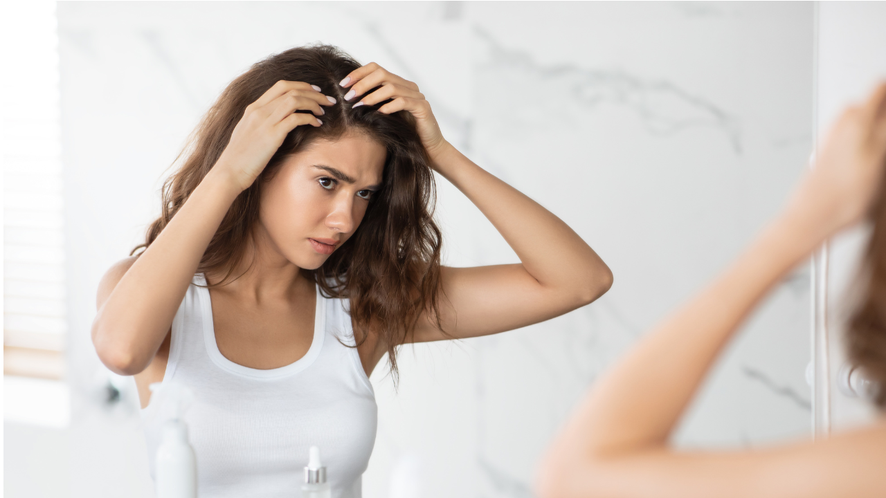 Mulher observando seu cabelo no espelho