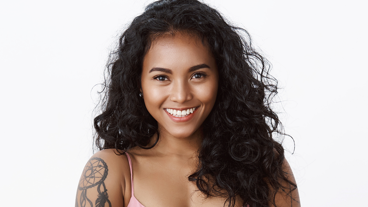 Mulher de cabelo cacheado sorrindo