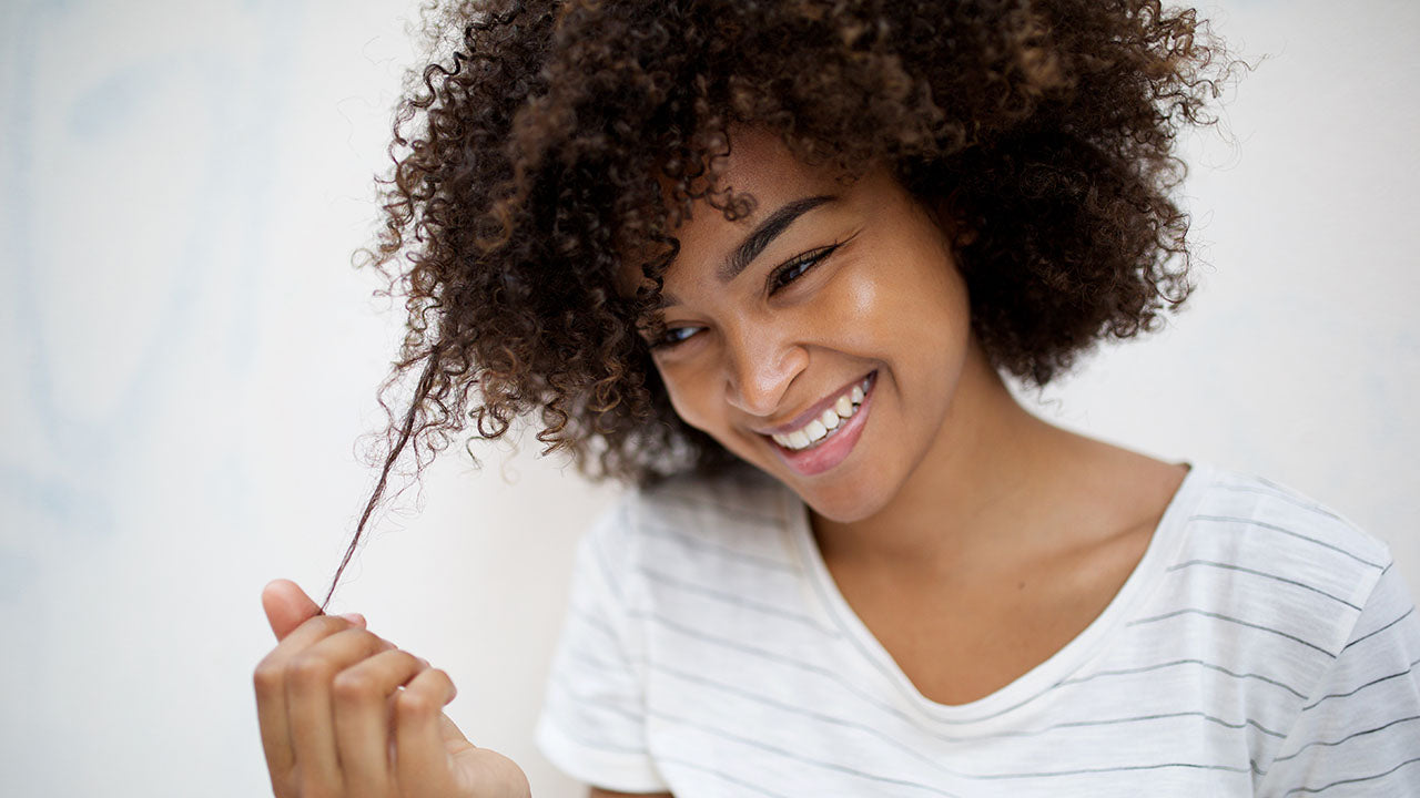 Mulher segurando os fios após fazer fitagem no cabelo