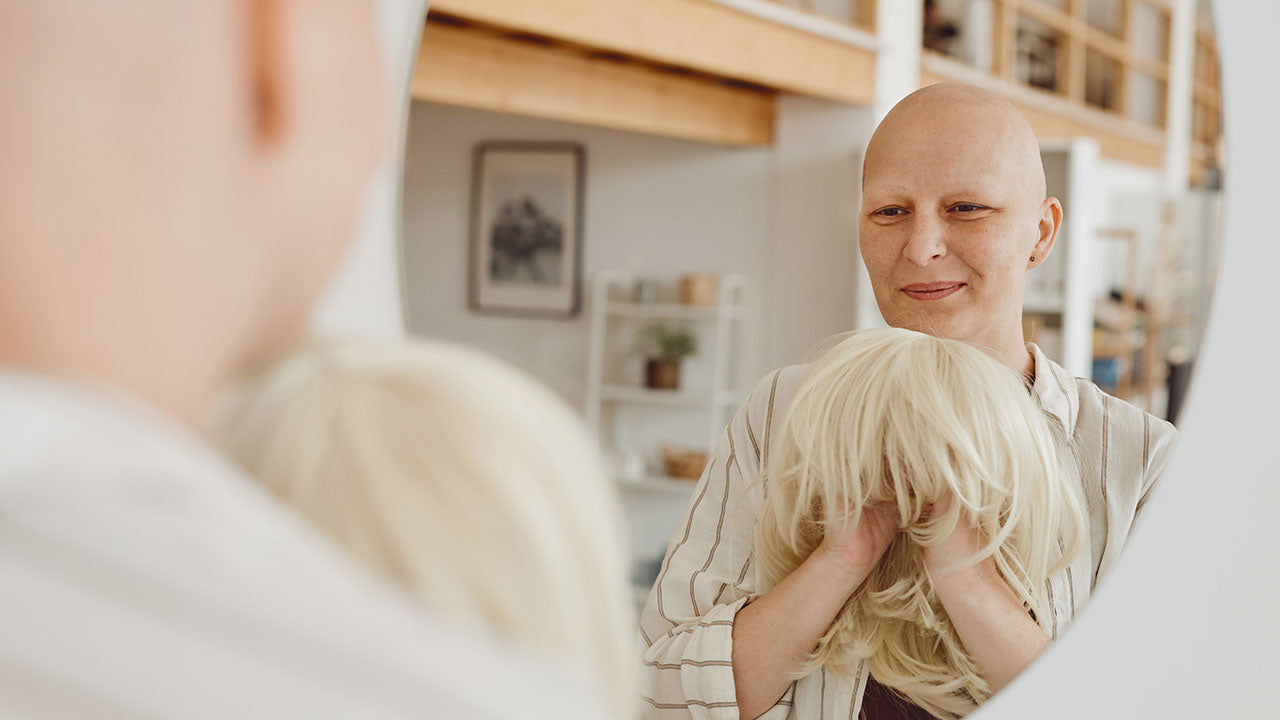 Mulher em tratamento de câncer segurando uma peruca