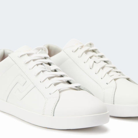 Single all white Prime sneaker by Rollie has tennis shoe styling in profile position & grey background.