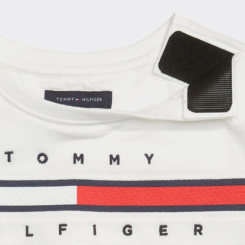 Alt text: Tee styled dress in white with Tommy Hilfiger classic logo across the chest. Dress shown on off-white background. 