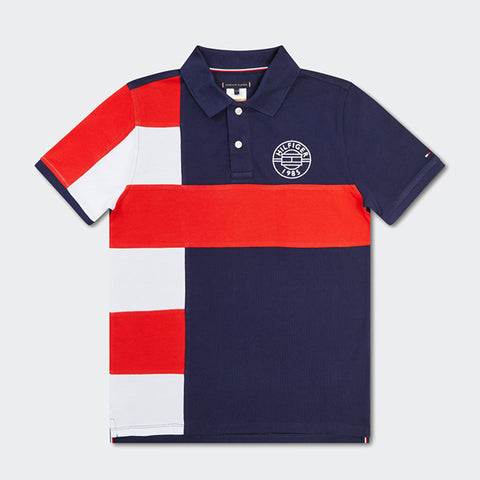 Colourblock badge polo in red/white strip on the right & solid navy and signature badge on the left.