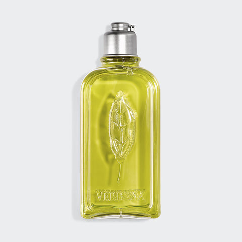 Verbena Shower Gel in clear lotion bottle with a leaf embossing on bottle with a metallic cap on grey background.