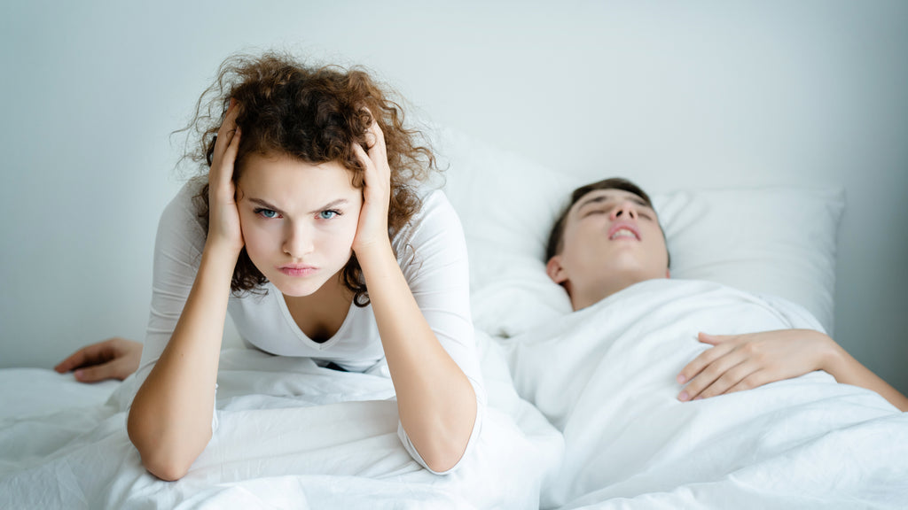 Wife frustrated with husbands snoring on bed