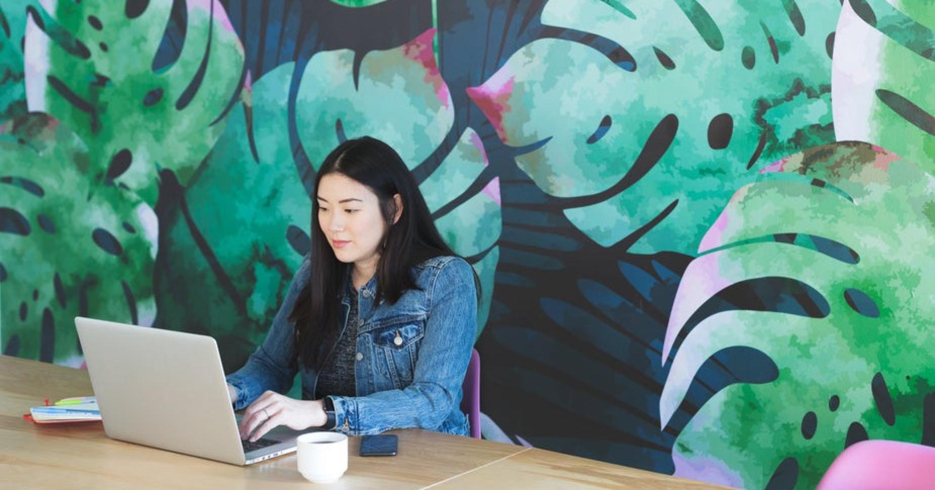 Jeune femme travaillant sur son ordinateur portable dans un café