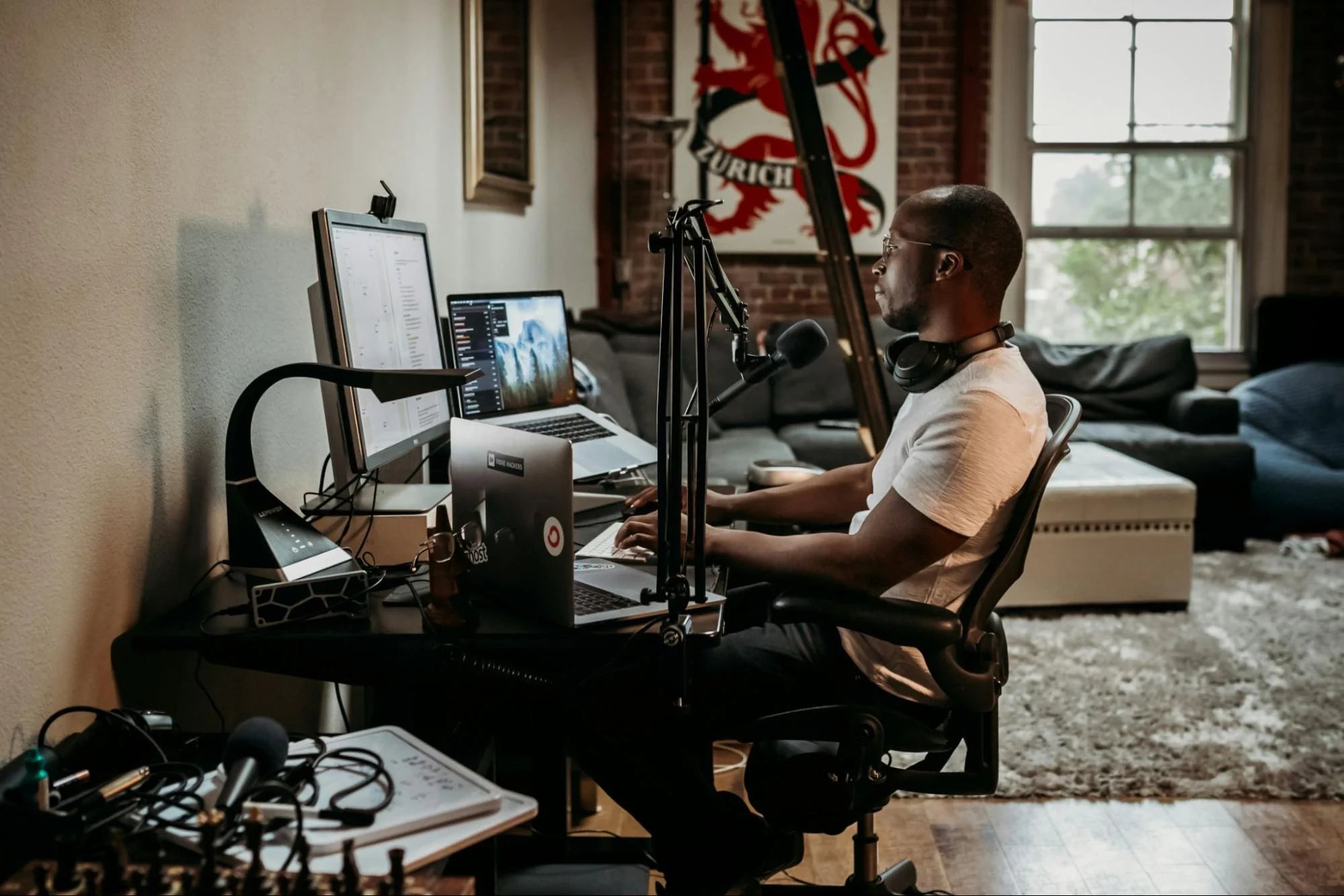 Un homme est assis à un bureau avec du matériel de podcasting