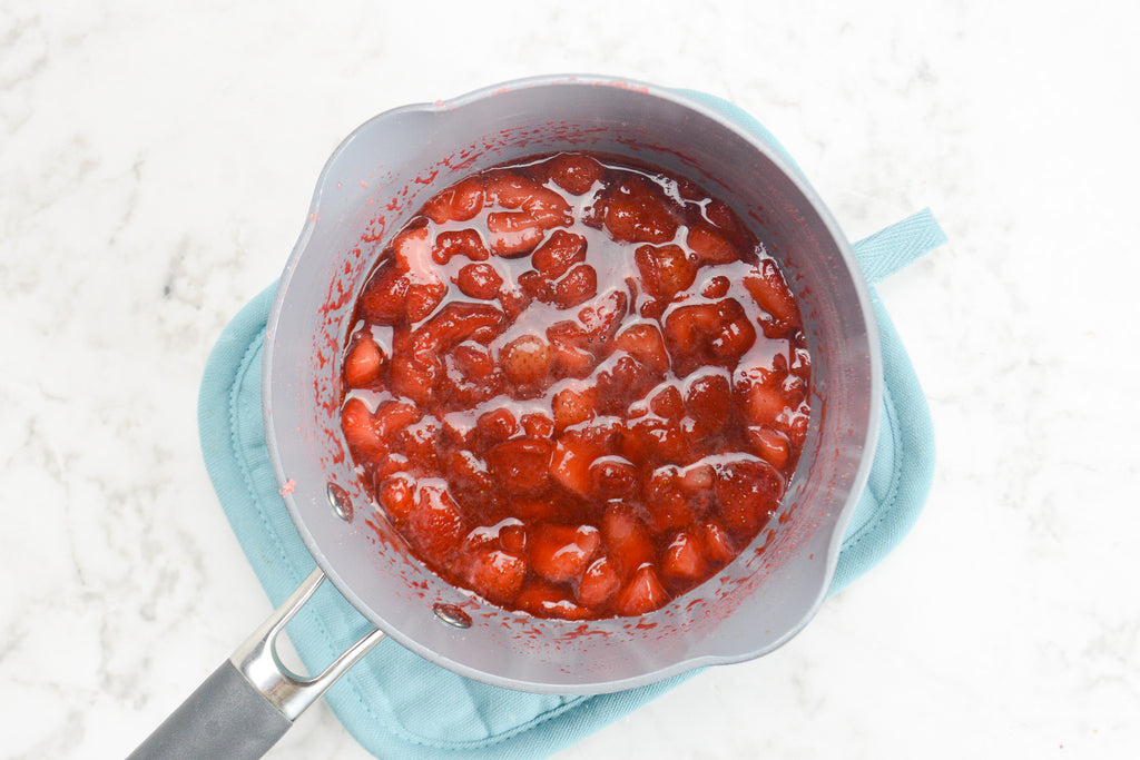 Saucepan filled with cooked strawberry compote