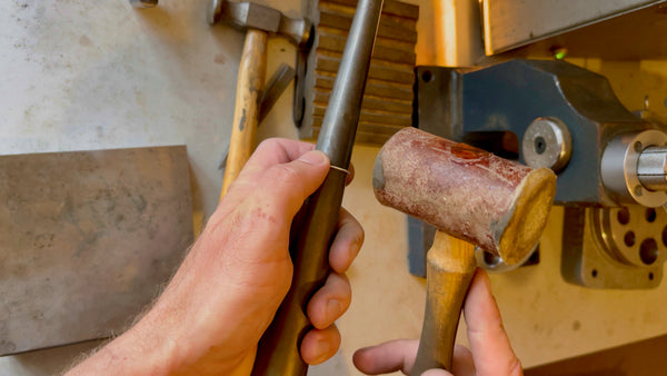 shaping a silver ring with precision, using a triblet and rawhide mallet.