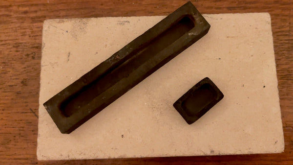 A set of two well-used graphite ingot molds, narrating tales of numerous successful casts.