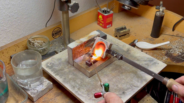 Capturing the critical moment of pouring molten gold into a preheated graphite ingot mold