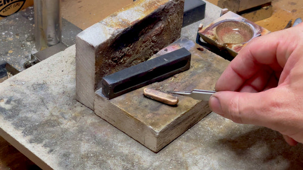 An image portraying a golden ingot freshly released from the confinement of its graphite mold, ready to be transformed into a masterpiece.