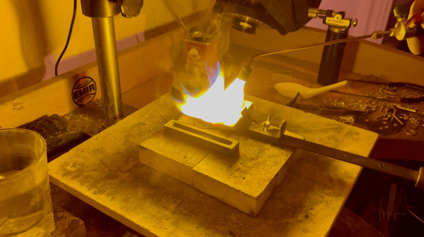 A crucible containing molten gold, heated to the perfect temperature, ready to be poured into an ingot mold.