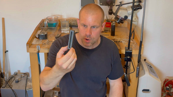 A hand expertly holding a graphite ingot mold, demonstrating the first-hand experience of working with graphite molds at Roberts & Co.