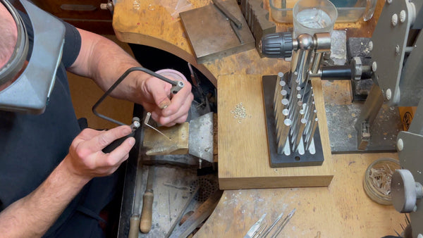 jeweller sawing a coil of jump rings