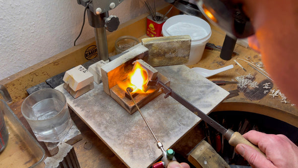 The critical moment of pouring molten gold into the graphite ingot mold