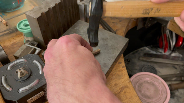 Peening process on gold ingot, preparing it for its next transformation