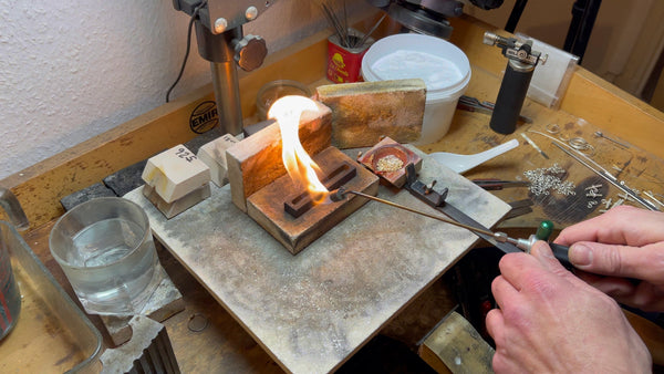 The critical moment of pouring molten gold into the ingot mold
