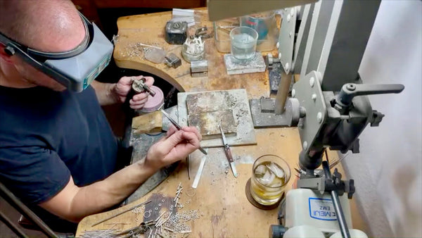 Close-up inspection of intricately designed T-bar pendants.