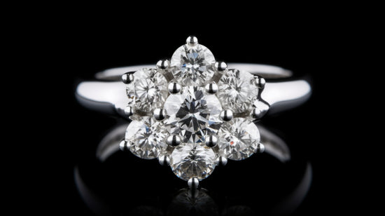 Ring shoulders with three small diamonds set in a white gold with a beaded border.