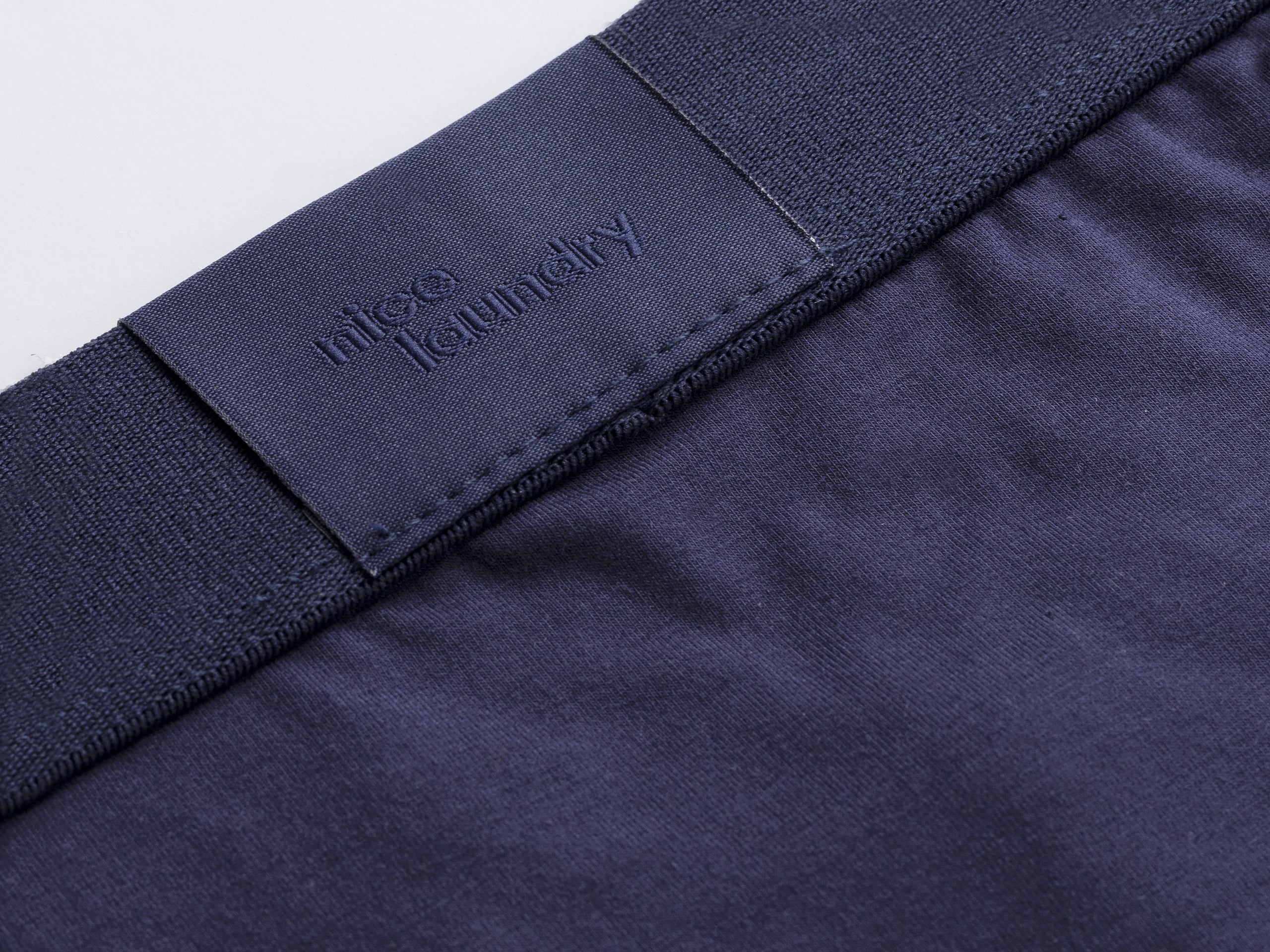 Close up detail shot of back label found on navy blue brief.