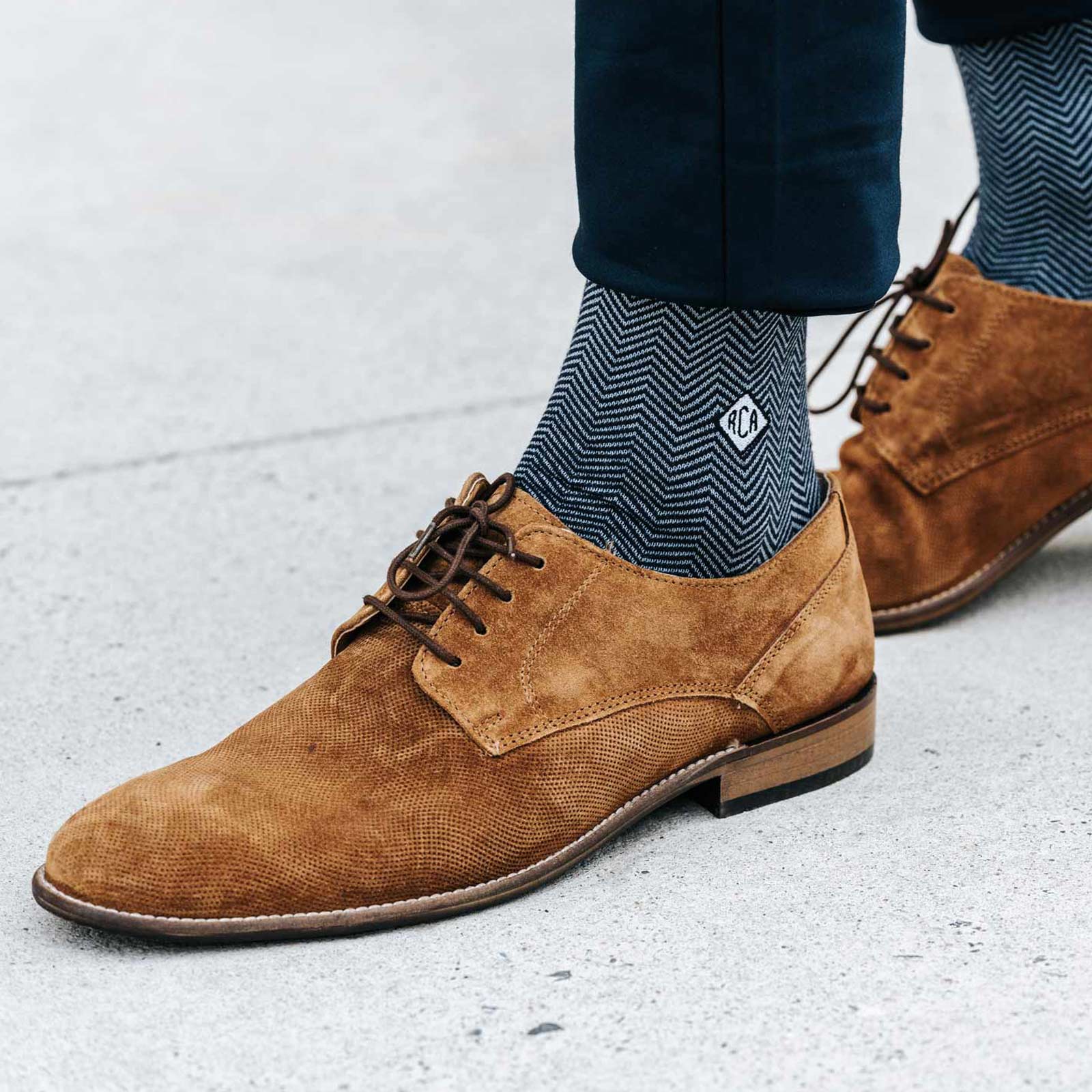 Herringbone monogrammed socks paired with light brown dress shoes.