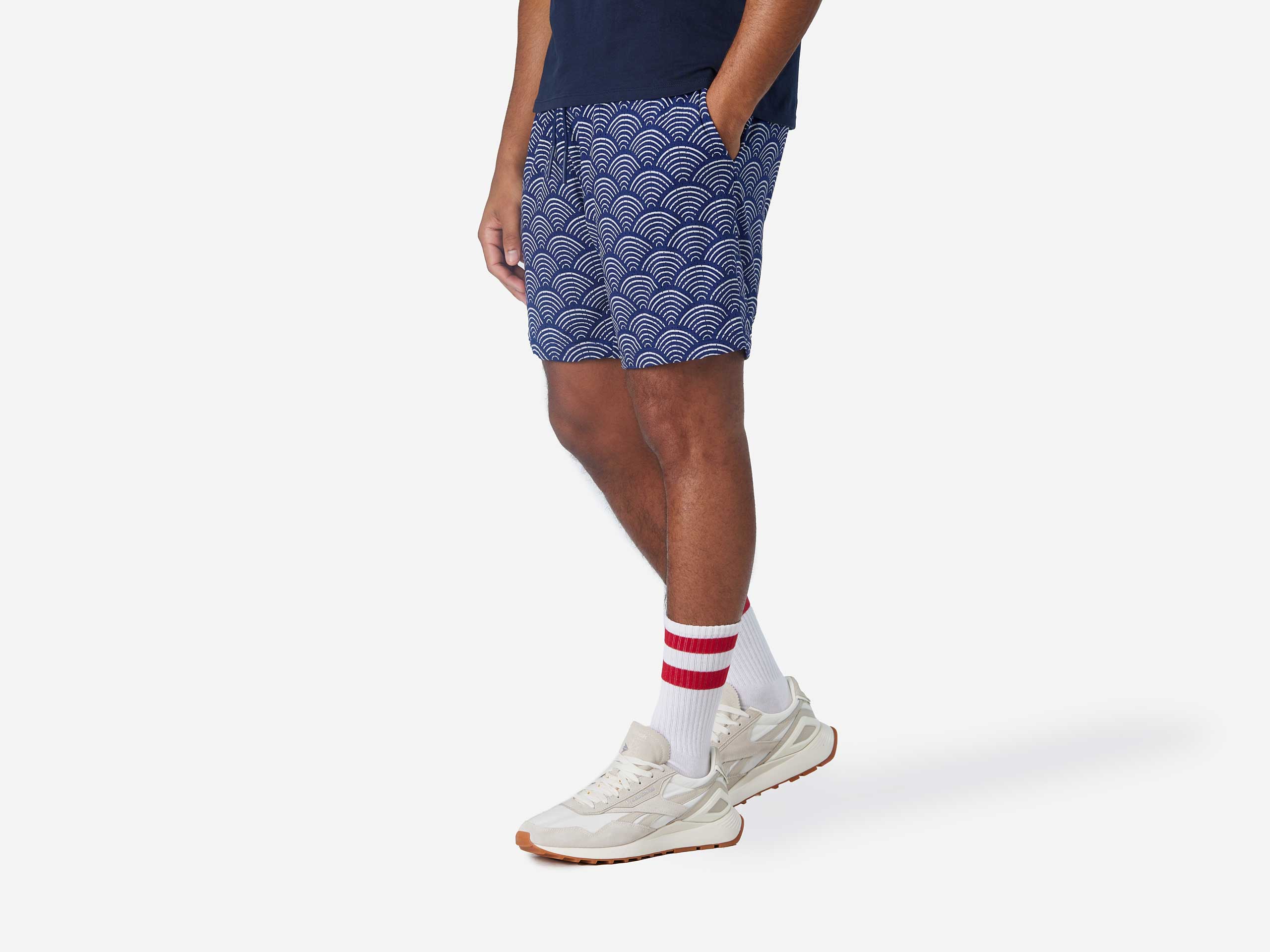 Side view of man wearing blue lounge shorts with sunrise pattern.