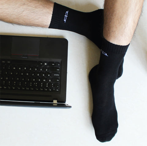 A person with the socks on. A laptop is kept on the side.