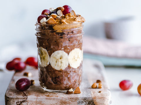 Dark chocolates oats topped with bananas, grapes, nuts, and peanut butter