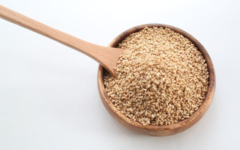 A wooden bowl with sesame seeds