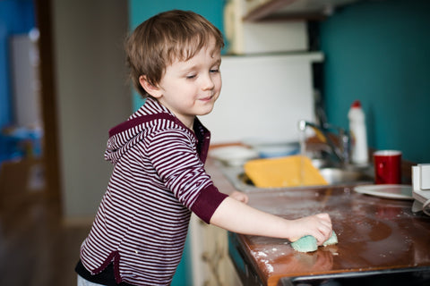 child cleaning the counter as a starter chore for kids