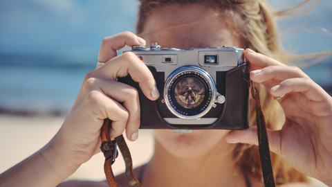 mom taking a photo at the beach