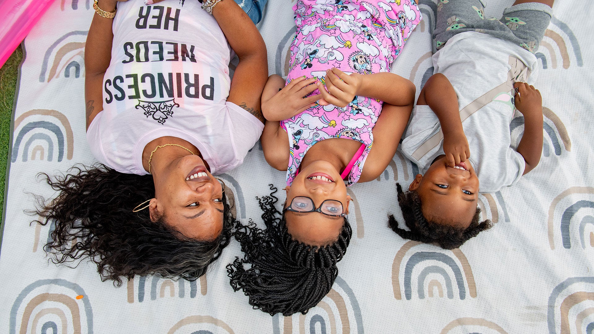 family laying on California Beach Co. blanket