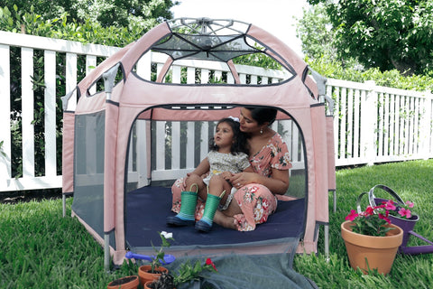 A mother and daughter playing inside the pop n go playpen 