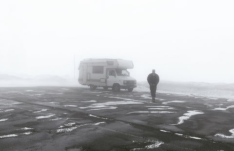 michel kropf porte ses lunettes de glacier au col du simplon devant son camping car en road trip splitboard avec casam à travers les alpes suisses