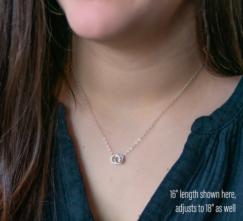 our dainty and symbolic necklace features 2 connected rings with CZ accents