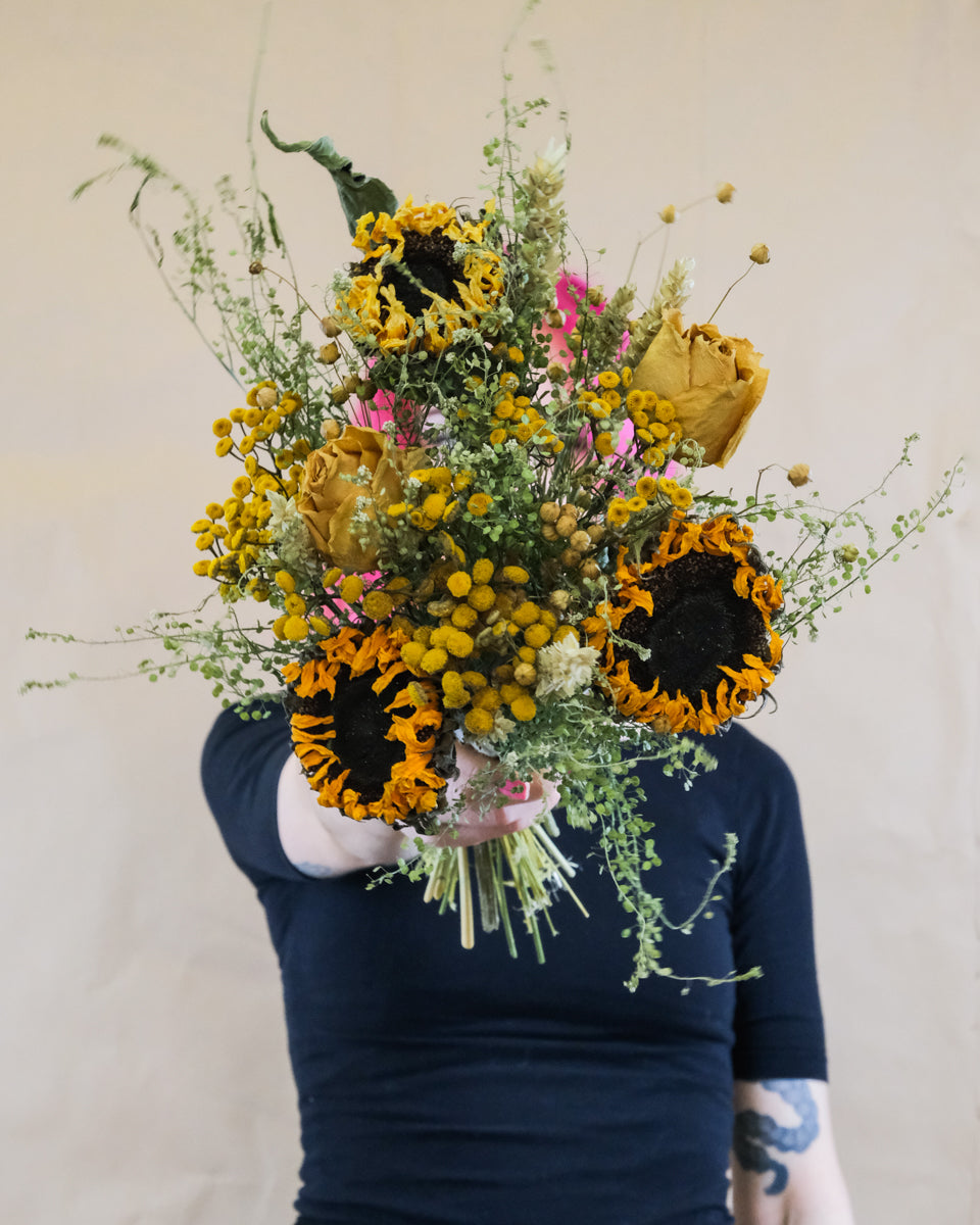 Strauss aus getrockneten Sonnenblumen und anderen gelben Trockenblumen