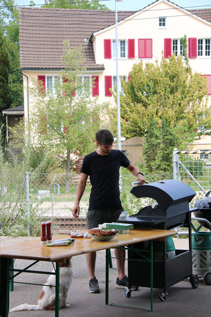 Grillmeister Sven steht vor dem Grill.