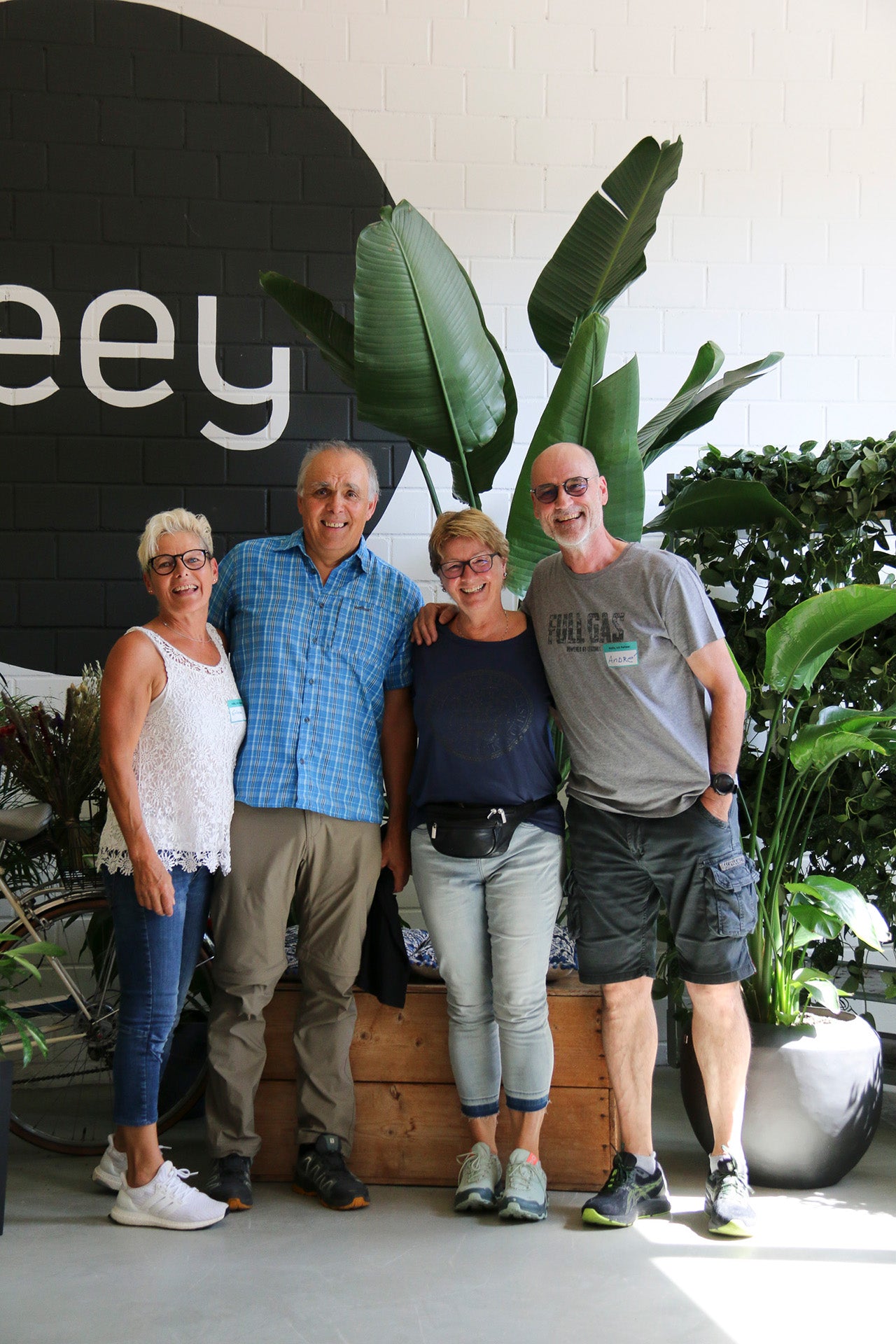 Vier Personen vor dem feey-Logo und einer grossen Strelitzie.