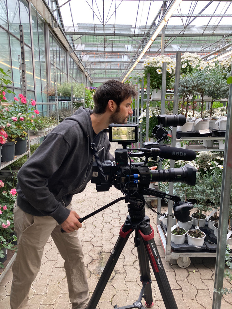 Janko hantiert in der Blumenbörse Mörschwil an einer grossen Filmkamera herum