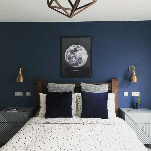 Brass industrial lights in a dark blue bedroom