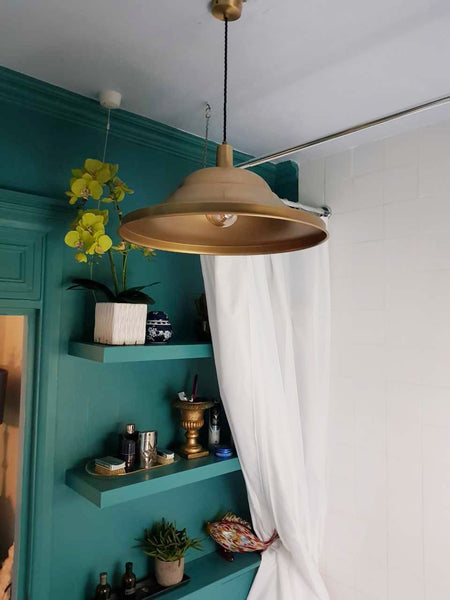 Emerald coloured walls paired with brass toned industrial lights