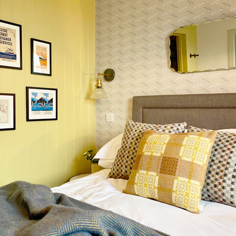 A bedroom with yellow walls and vintage lighting by Industville